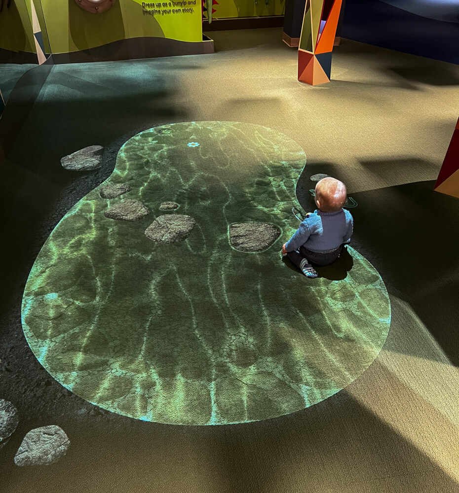 A child enjoying a floor projection at the Discovery Centre at the National Museum of Australia