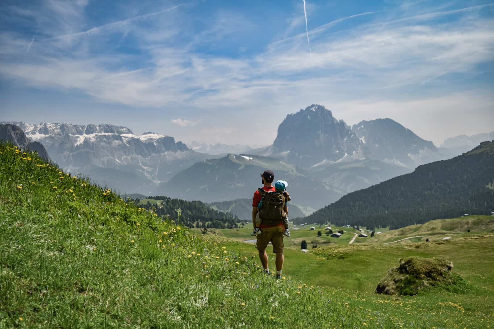 A man carrying his son in a carrier on a mountain hike