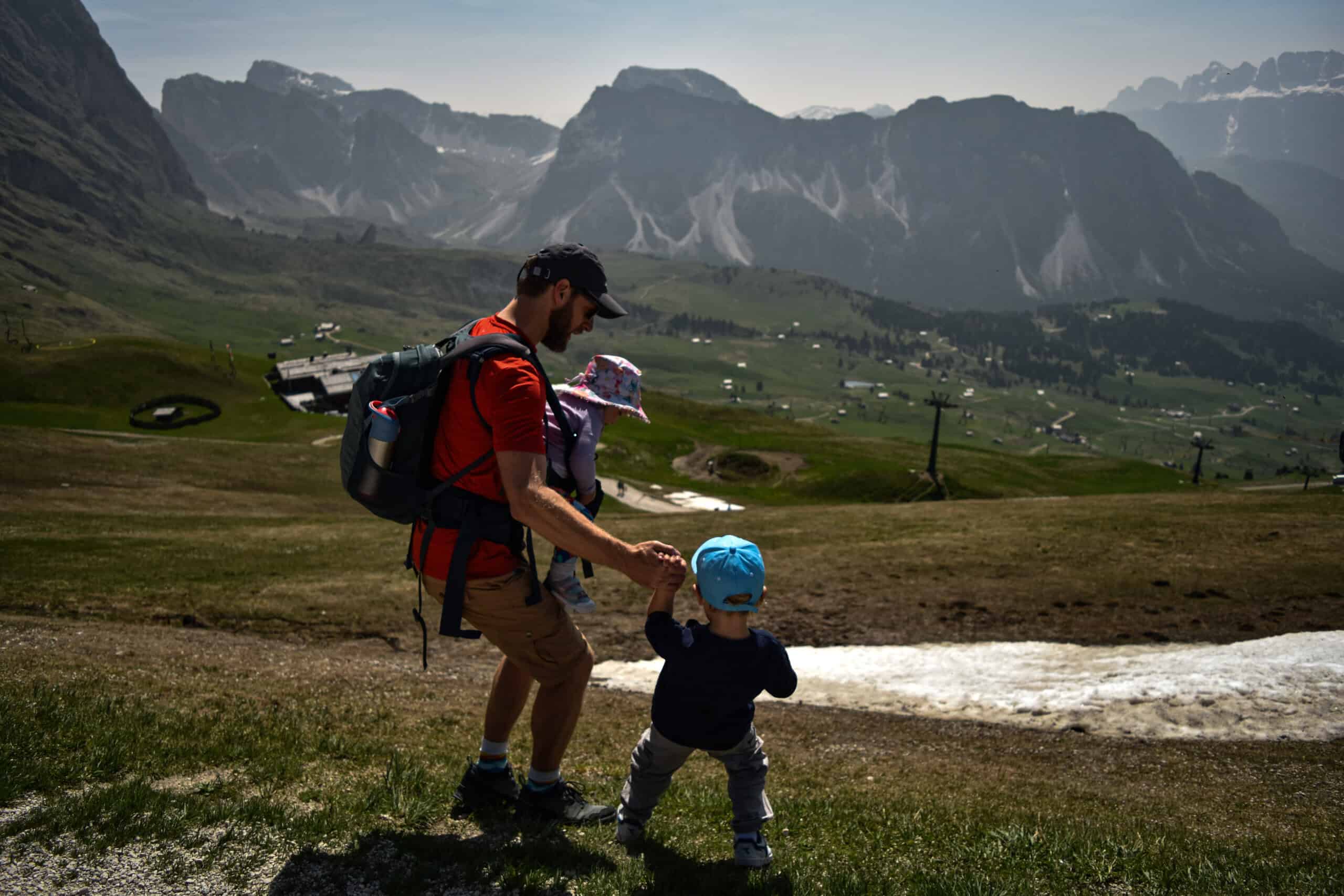 young kids walk down a hill to touch snow