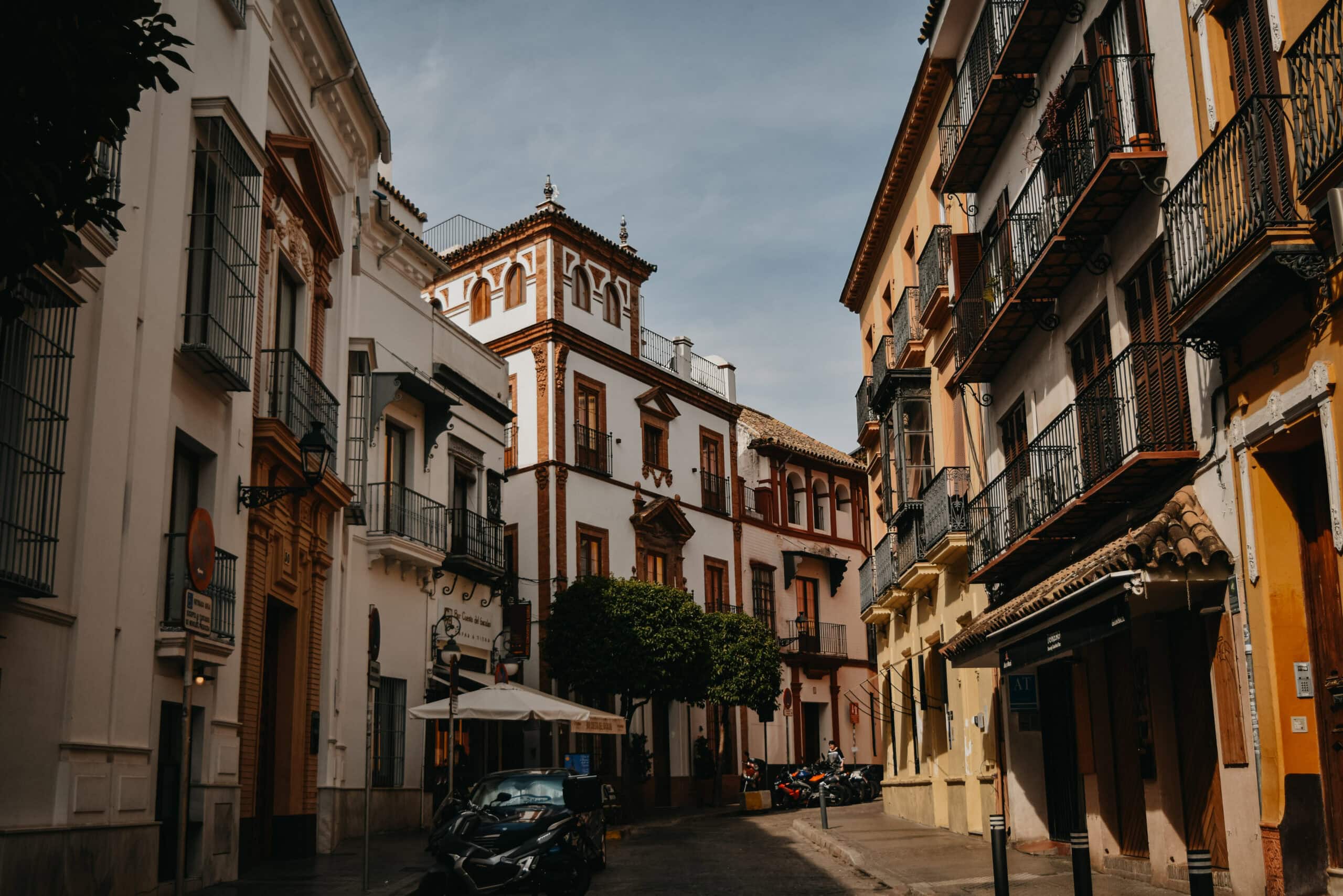 Typical Seville street with wrought-iron balconies and warm-hued façades.