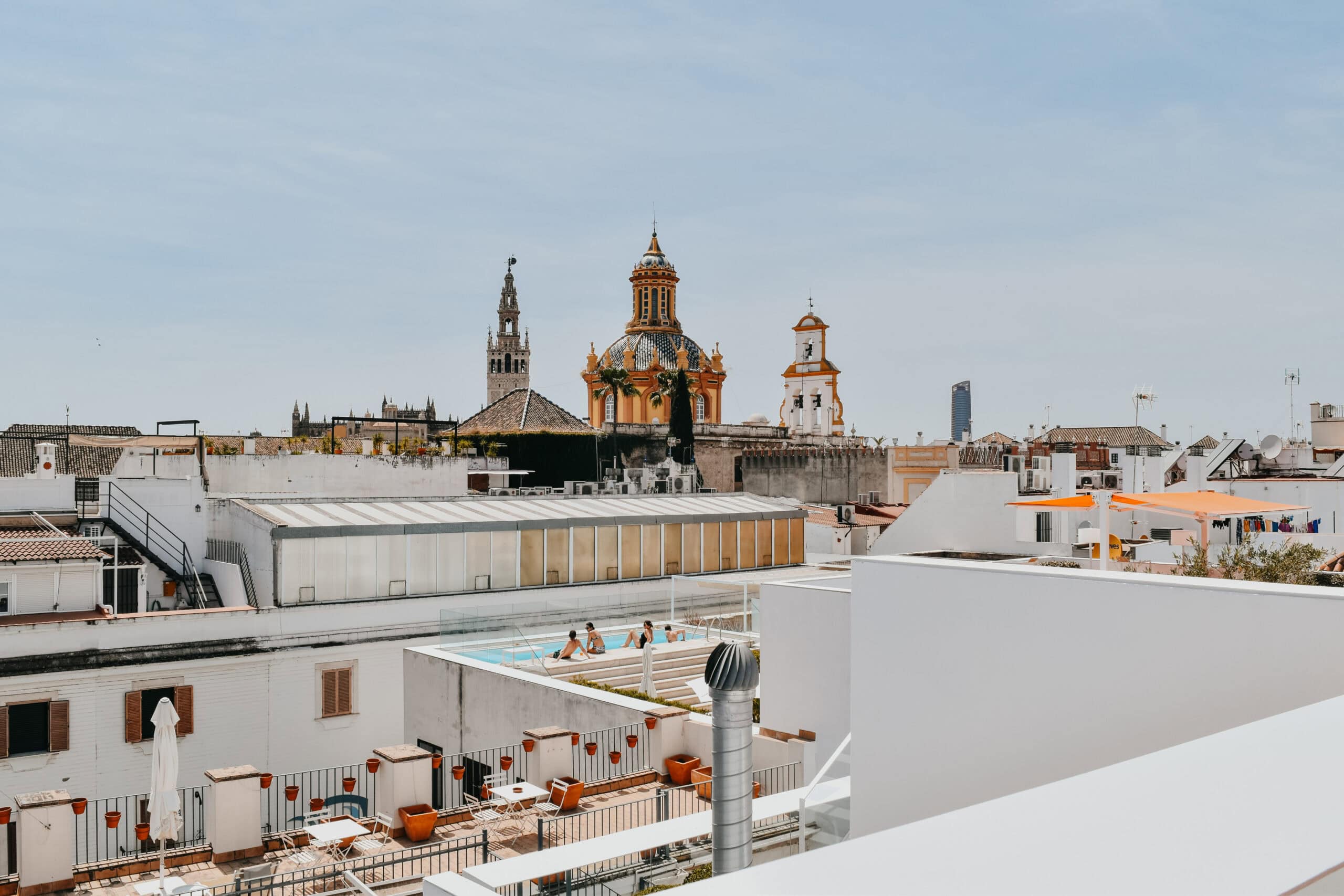 Rooftop outlook over Seville showing church domes and a small rooftop pool.